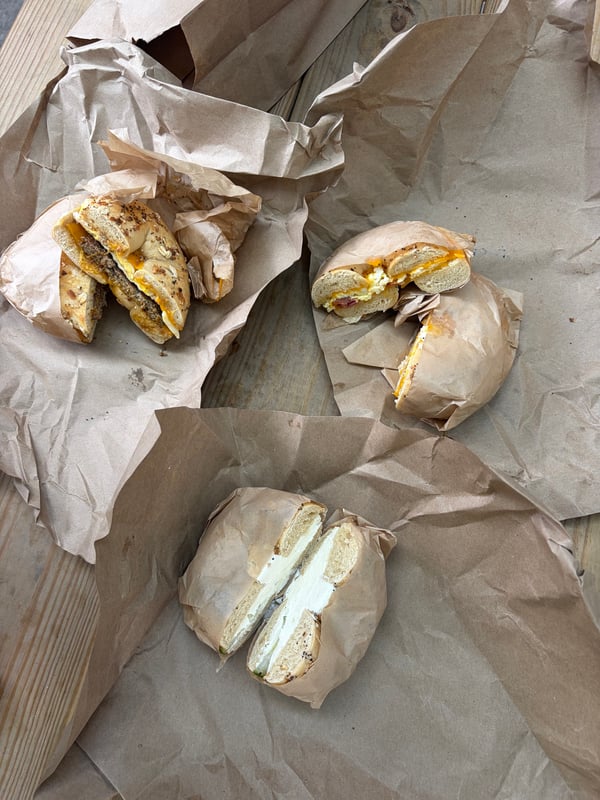 Bagel sandwiches and a cream-cheese bagel on paper wrappers at Beans & Bagels.