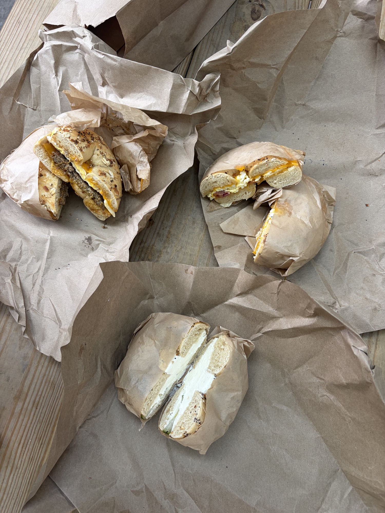 Bagel sandwiches and a cream-cheese bagel on paper wrappers at Beans & Bagels.